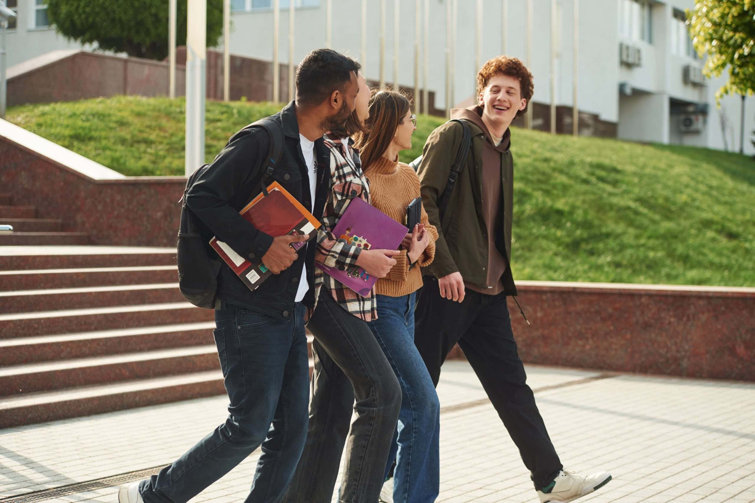 Group of college students walking and talking on a university campus