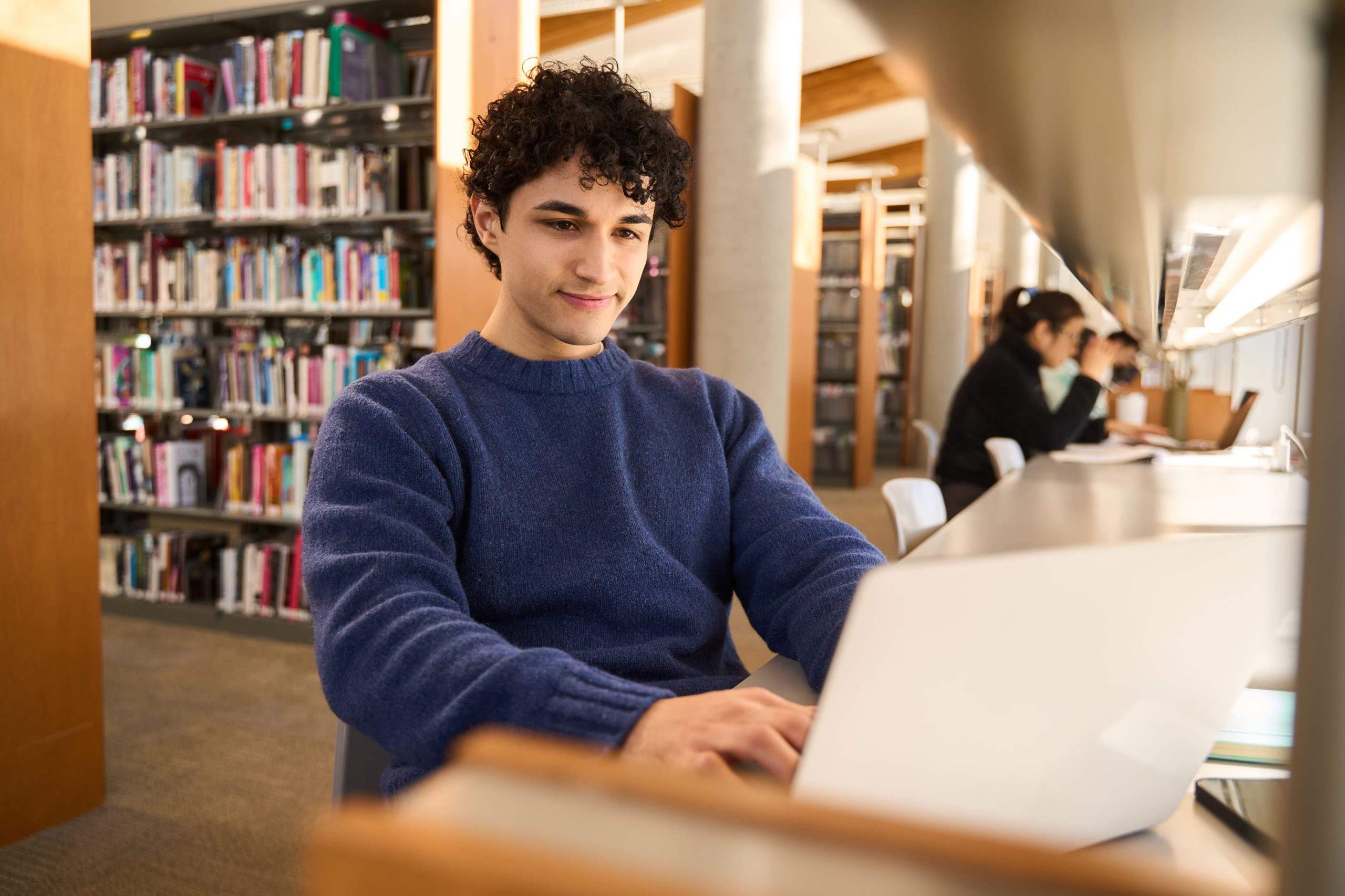College student working on a laptop in a university library
